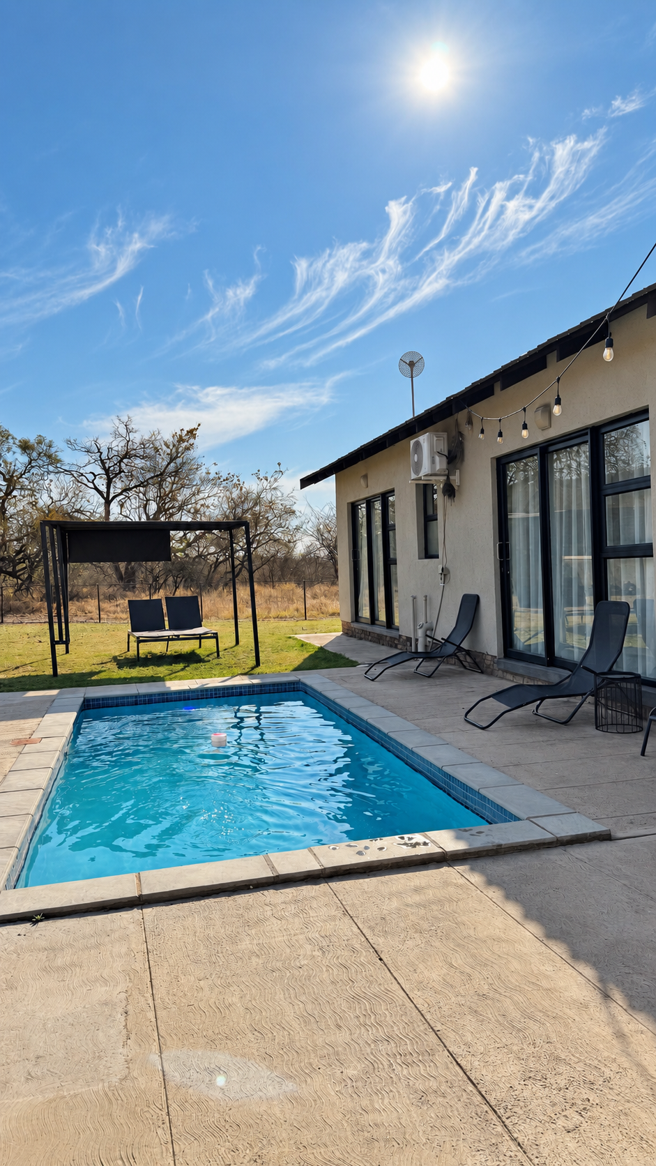 Private swimming pool and terrace at Sango Hartbeespoort beneath a bright blue sky