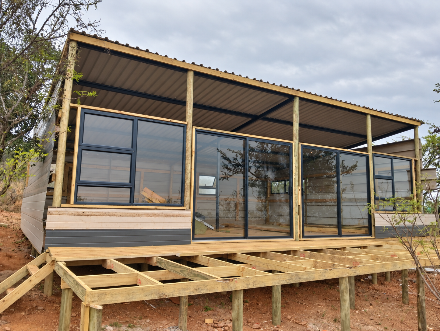 New unit at Sango Hartbeespoort taking shape, with a raised timber deck and full-height glass under a covered roof
